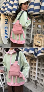 Close-up detail of cute pink frog crossbody bag featuring long plush legs and eyes