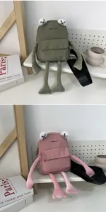 Detailed close-up of a creative frog-shaped plush bag featuring unique X-shaped eye embroidery