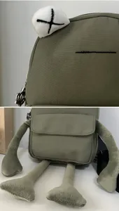 Detailed view of the embroidered X eye and plush limbs on this green frog crossbody bag