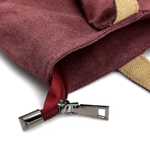 Close-up of a burgundy canvas tote bag featuring a durable metal zipper and handles