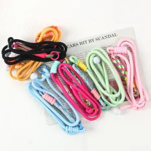 Detailed view of colorful braided mobile phone lanyards with adjustable buckles and pearl charms.