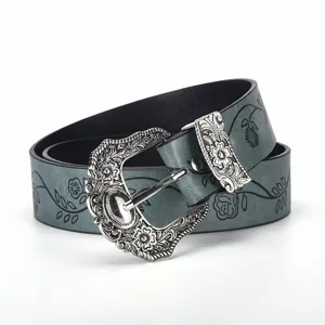 Close-up of vintage carved buckle belt with elegant black leaf and clover prints