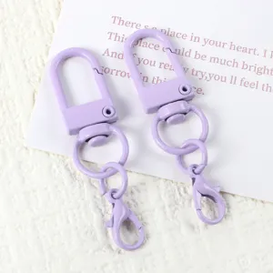 Detailed view of purple baked paint U-shaped swivel keychain hooks and lobster clasps.