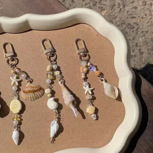 Set portachiavi con conchiglie stile spiaggia e graziosi ciondoli a stella marina dorata.