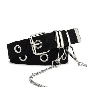 Detalle de cinturón punk negro con ojales metálicos y cadenas decorativas plateadas