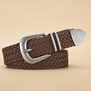 Detail of a vintage brown braided PU belt with distressed silver buckle and metal tip