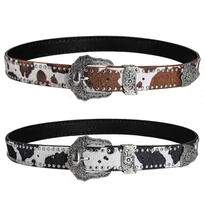 Western cow print leather belt with vintage metal carved buckle and rivets for stylish jeans wear.