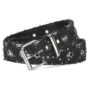 Closeup of black distressed denim punk belt with star grommets, sequins and metal buckle