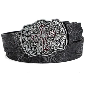 Detailed macro view of vintage embossed leather belt featuring an ornate silver cross buckle