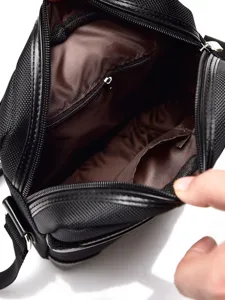 Interior view of black oxford messenger bag with brown lining and zip pocket