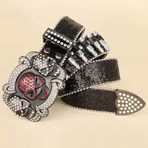 Close-up detail view of black hip hop belt with crystal skull buckle and decorative bullets