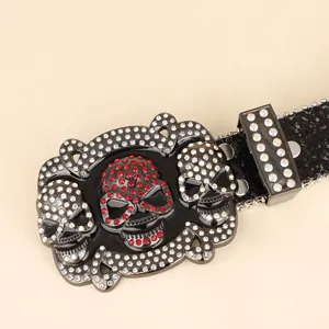 Close-up view of a luxury rhinestone-studded skull buckle on a glittery black belt