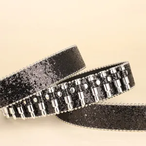 Detailed macro view showing the texture of a black sequined belt with silver bullet studs