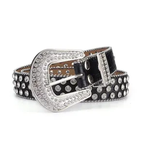 Close-up of sparkling rhinestone buckle and crocodile texture on punk leather belt
