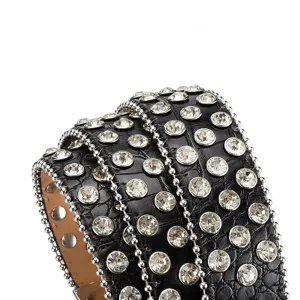 Close-up of black crocodile leather belt with large rhinestones and silver bead trim