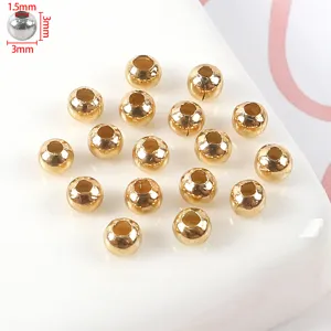 Primer plano de cuentas espaciadoras de metal dorado, superficie lisa para joyería DIY.