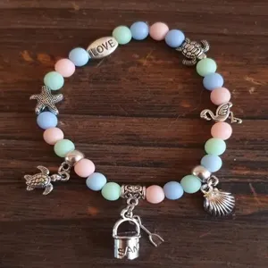 Pastel macaron color acrylic beaded bracelet featuring sea turtle and shell charms detail