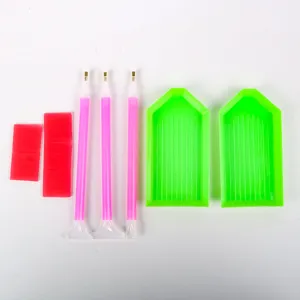 Complete DIY diamond painting tool kit with green trays, pink pens, and red wax pads.