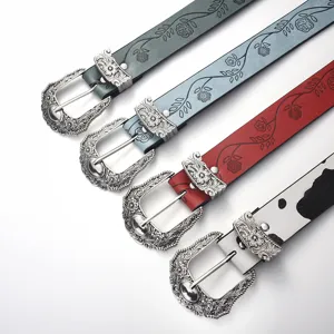 Detailed view of ornate silver carved buckles on multi-colored leather belts