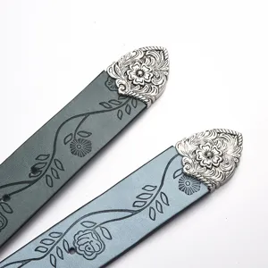 Close-up of vintage belts with floral prints and ornate silver-carved buckles detail