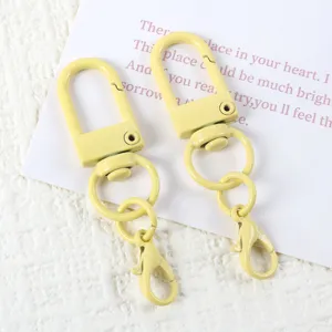 Yellow painted U-shape swivel snap hook and lobster clasp DIY keychain hardware detail shot.