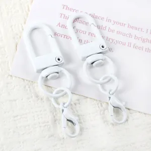Detailed close-up of white rotating snap hook and lobster clasp DIY keychain hardware accessory.