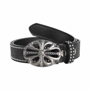 Detailed view of embossed black leather belt with ornate silver cross buckle and metal stud trim.