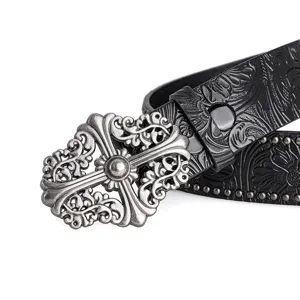 Detailed view of the vintage embossed leather belt with ornate gothic cross metal buckle.