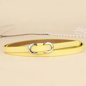 Close-up of a minimalist macaron yellow thin belt with a silver figure-8 buckle.