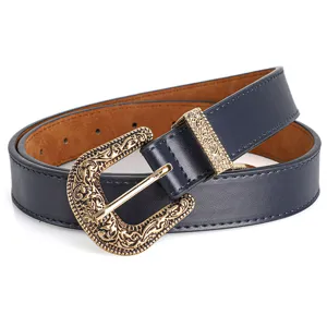 Detail view of a vintage navy blue belt featuring a classic engraved gold-tone pin buckle