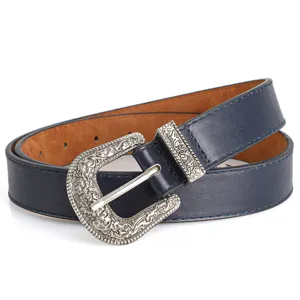 Close-up of vintage navy blue belt with an intricately carved silver pin buckle.