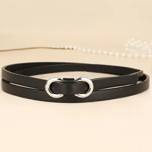 Detail of a slim black leather belt featuring a silver figure-eight metal buckle