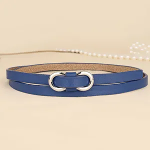 Detail of a thin blue leather belt featuring a silver figure-eight metal buckle.