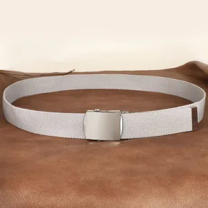 Grijs canvas riem detail met metalen gesp en geweven band op een bruine gestructureerde achtergrond.