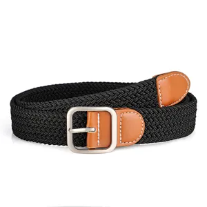 Close-up of black woven elastic belt with brown leather trim and silver metal buckle detail.