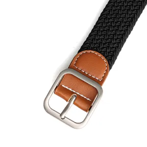 Close-up view of black woven elastic belt with brown PU leather trim and silver metal buckle detail.
