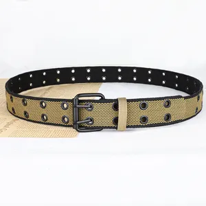 Canvas riem detail met dubbele oognagels, zwarte metalen gesp en contrasterend weefontwerp.
