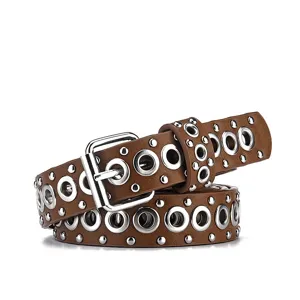 Detailansicht brauner Modegürtel mit silbernen Metallösen und Nietenverzierung.