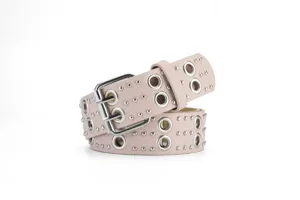 Detailed close-up of a punk-style pink leather belt featuring double grommets and metal studs.