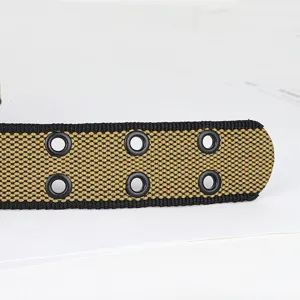 Canvas riem detail met dubbele metalen ogen en een fijne zwart-khaki gewoven textuur.