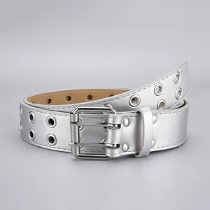 Détail de la ceinture punk argentée à double œillet avec boucle métallique et rivets.