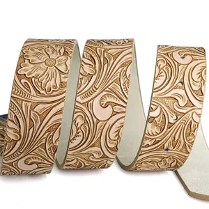 Detailed macro view of vintage embossed floral pattern on a beige leather belt