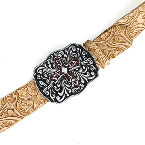 Close-up detail of embossed vintage belt with ornate red cross carved buckle