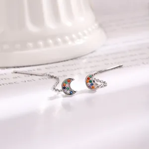 Detailed view of silver threader earrings featuring colorful cubic zirconia crescent moon pendants.