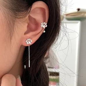 Détail rapproché du boucle d'oreille patte de chat en argent et de son ear cuff assorti