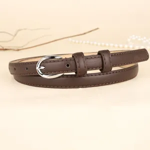 Detail of a slim dark brown vintage leather belt with silver oval buckle