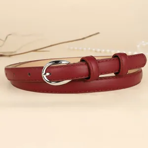 Detailed view of elegant burgundy thin leather belt with a silver horseshoe-style buckle