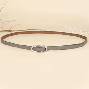 Detail of a slim gray leather belt with a silver figure-eight metal buckle.