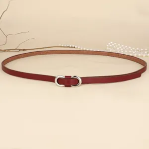 Detailed view of a slim red leather belt featuring a silver infinity-shaped metal buckle