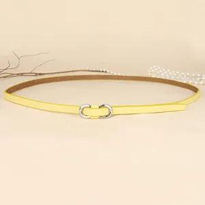 Close-up of a thin macaron yellow belt for women with a silver figure-8 buckle.
